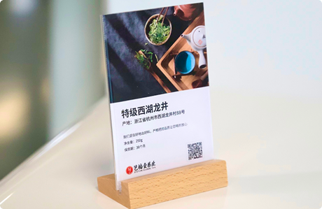 门店桌面上的特级西湖龙井台卡，卡面印着产品信息和二维码