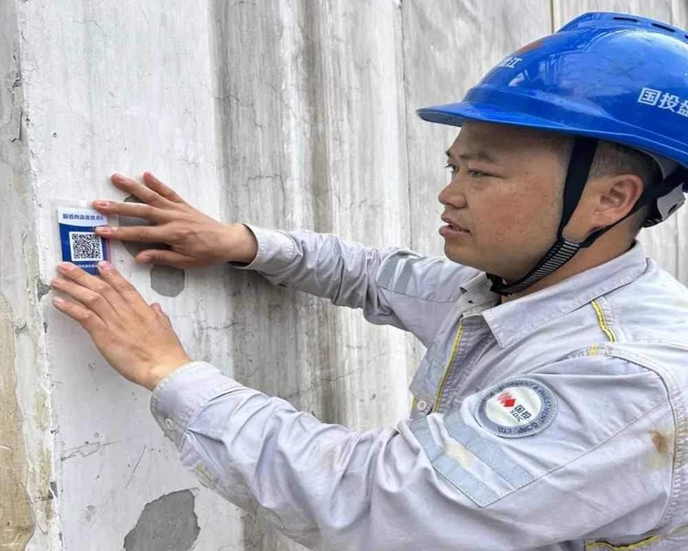 脱硫超低排放改造项目现场，工作人员把检查二维码贴在作业区域的墙面上