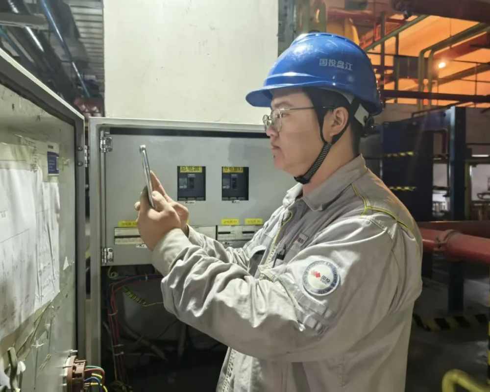 电气一次专业巡检人员在配电柜前用手机扫码填写巡检记录
